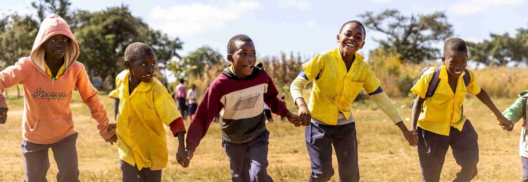 A girl laughing during a game on the school field.